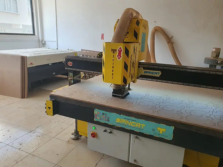 Tesisimizdeki CNC kesim makinesi ve arka planda lazer kesim ünitesi